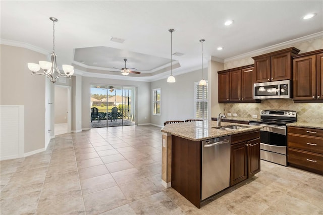 4891 Maymont Park Cir, Bradenton, FL 34203 - kitchen featuring appliances with stainless steel finishes, sink, hanging light fixtures, a raised ceiling, and crown molding