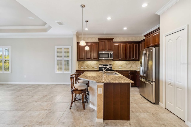 4891 Maymont Park Cir, Bradenton, FL 34203 - kitchen with crown molding, appliances with stainless steel finishes, decorative light fixtures, and a kitchen island with sink