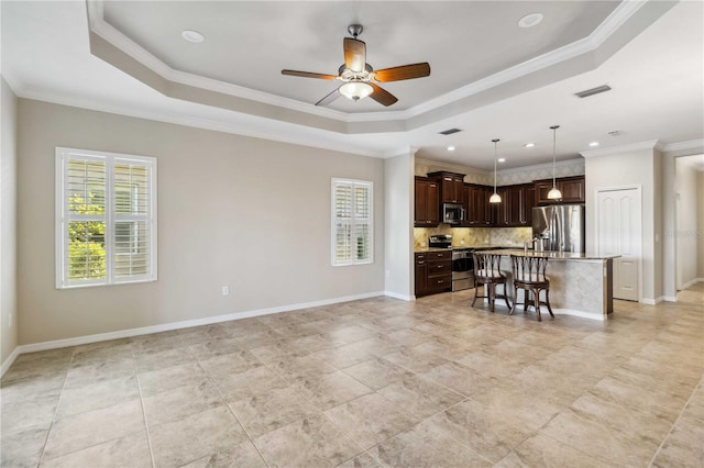 4891 Maymont Park Cir, Bradenton, FL 34203 - kitchen with crown molding, a center island, stainless steel appliances, and a raised ceiling