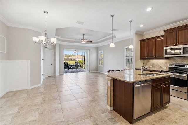 4891 Maymont Park Cir, Bradenton, FL 34203 - kitchen featuring a raised ceiling, an island with sink, sink, stainless steel appliances, and crown molding