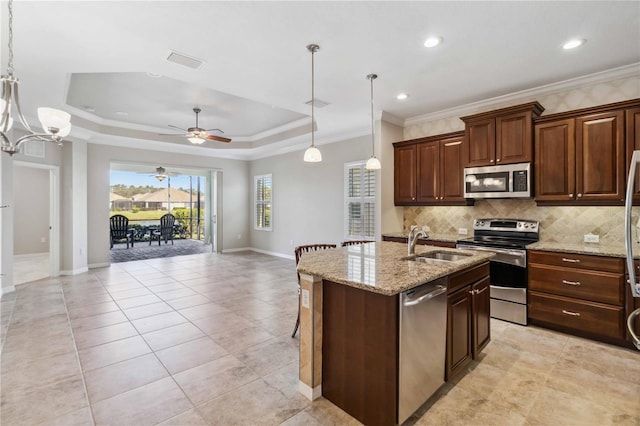 4891 Maymont Park Cir, Bradenton, FL 34203 - kitchen with pendant lighting, a raised ceiling, an island with sink, and appliances with stainless steel finishes