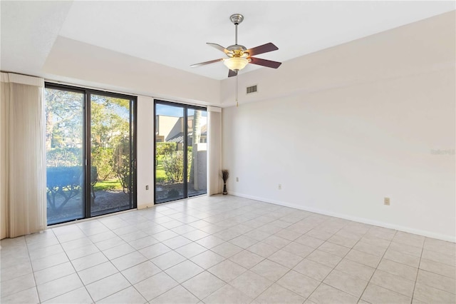 tiled spare room featuring ceiling fan