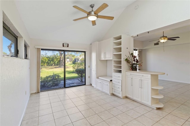 interior space with high vaulted ceiling, white cabinets, light tile patterned floors, ceiling fan, and kitchen peninsula