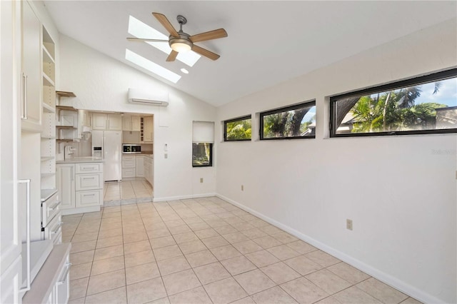 interior space with light tile patterned flooring, ceiling fan, vaulted ceiling with skylight, and an AC wall unit