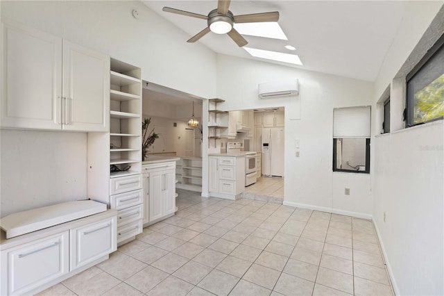 kitchen featuring light tile patterned floors, white appliances, white cabinetry, lofted ceiling with skylight, and a wall mounted AC