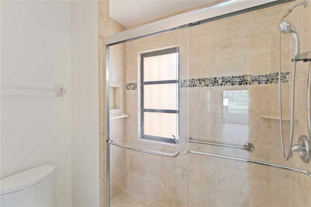 bathroom featuring an enclosed shower and toilet