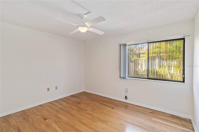 spare room with ceiling fan, light hardwood / wood-style floors, and a textured ceiling