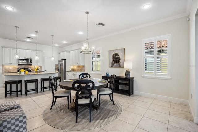 dining space featuring light tile patterned floors, baseboards, visible vents, and crown molding