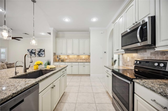 kitchen featuring light tile patterned floors, a sink, white cabinets, appliances with stainless steel finishes, and ornamental molding