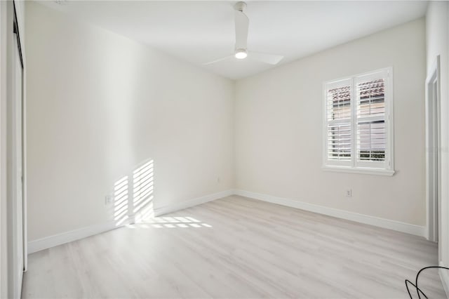 spare room with light wood-style floors, ceiling fan, and baseboards