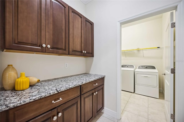 laundry room with laundry area, light tile patterned flooring, and washer and clothes dryer