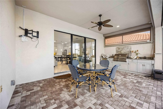 view of patio featuring ceiling fan, an outdoor kitchen, outdoor dining area, and grilling area