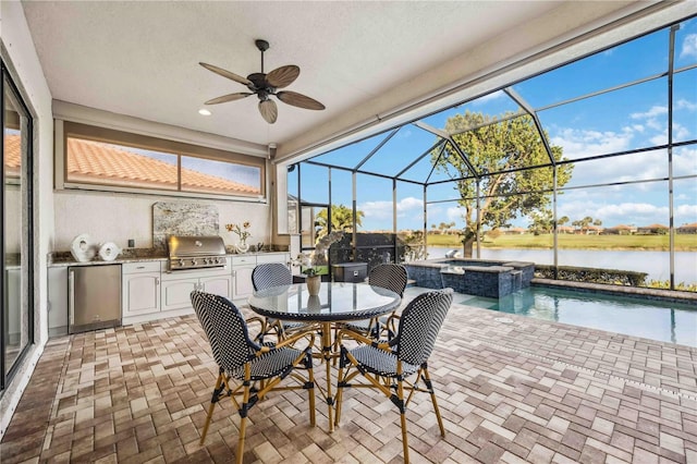 view of patio with an outdoor kitchen, a ceiling fan, a lanai, a grill, and a pool with connected hot tub