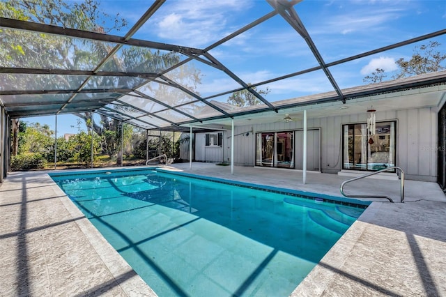 pool featuring a patio area, glass enclosure, and a ceiling fan