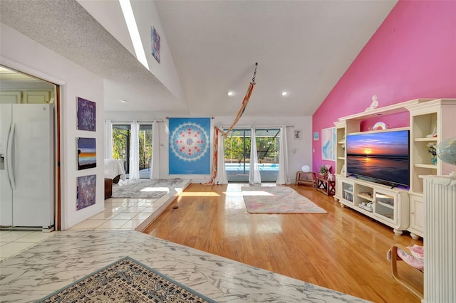 living area featuring high vaulted ceiling and marble finish floor