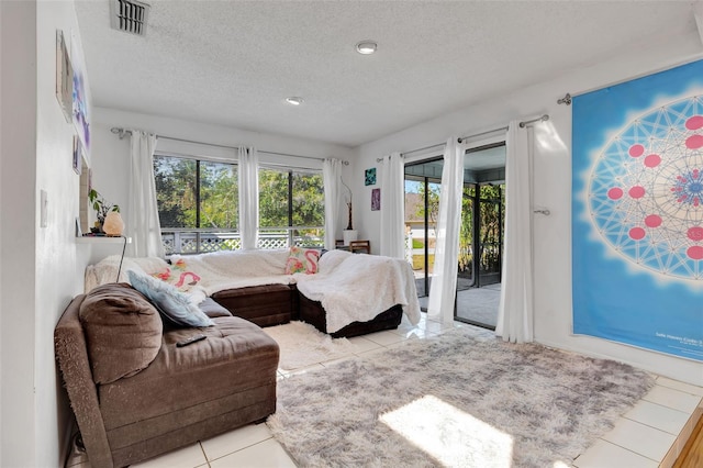 living room featuring visible vents, a textured ceiling, and tile patterned floors