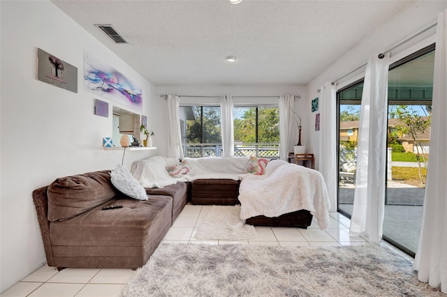 tiled bedroom featuring access to outside, visible vents, and a textured ceiling