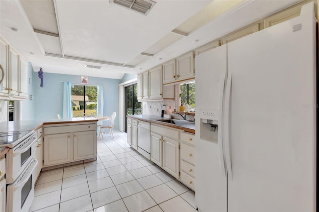 kitchen with light tile patterned floors, visible vents, decorative backsplash, a sink, and white appliances