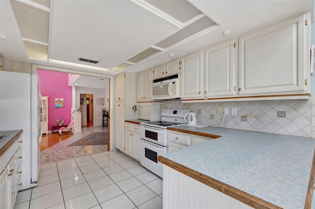 kitchen featuring light tile patterned floors, visible vents, decorative backsplash, white cabinetry, and white appliances