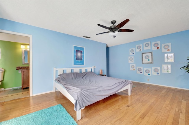 bedroom with visible vents, ceiling fan, a textured ceiling, wood finished floors, and baseboards