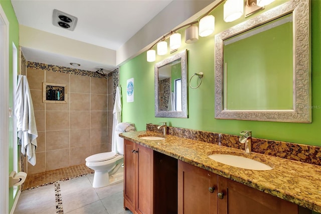 full bath featuring double vanity, a sink, toilet, and tile patterned floors