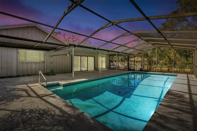 pool at dusk with glass enclosure, an outdoor pool, and a patio