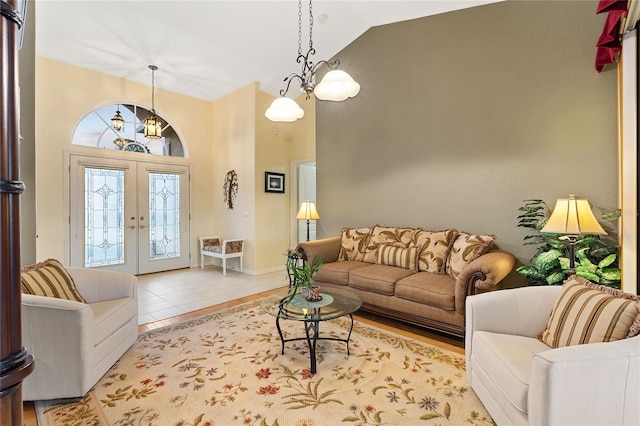 living room with light tile patterned floors, high vaulted ceiling, and french doors