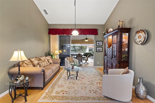 living room featuring high vaulted ceiling and light hardwood / wood-style floors