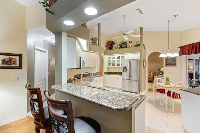 kitchen with kitchen peninsula, pendant lighting, ceiling fan, stainless steel appliances, and white cabinets