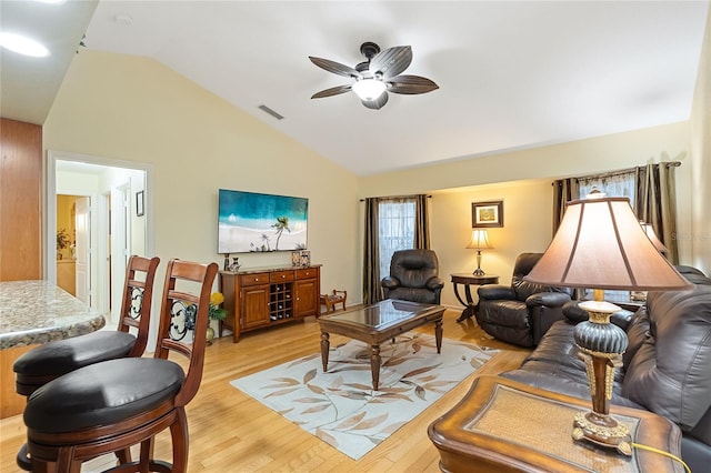 living room with ceiling fan, lofted ceiling, and light hardwood / wood-style flooring