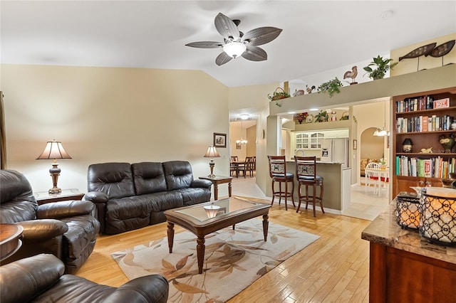 living room with ceiling fan, lofted ceiling, and light hardwood / wood-style floors