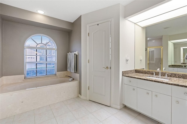 bathroom with vanity, tile patterned flooring, and plus walk in shower