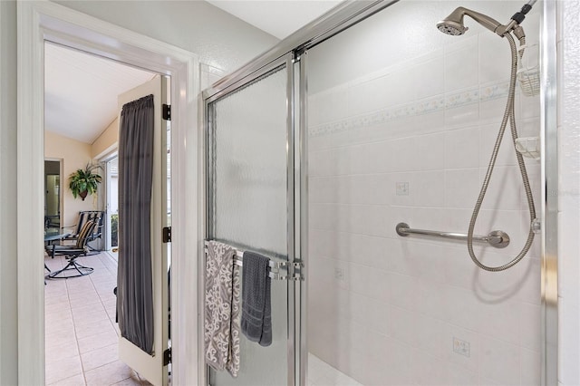 bathroom with tile patterned flooring, a shower with shower door, and lofted ceiling