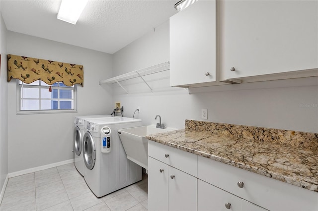 laundry area with sink, light tile patterned floors, cabinets, independent washer and dryer, and a textured ceiling