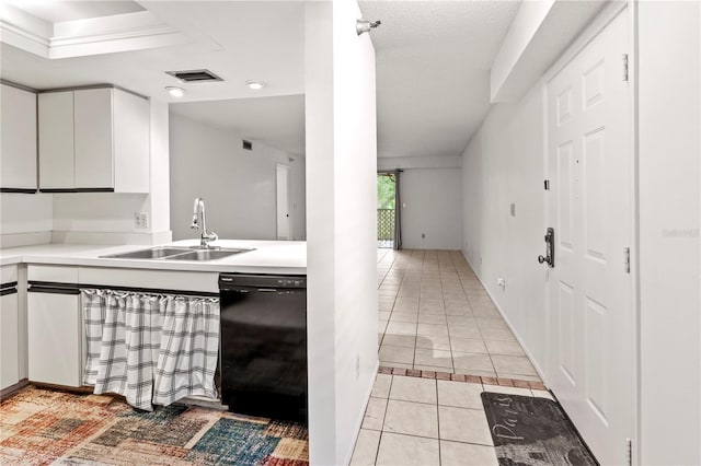 kitchen featuring light tile patterned flooring, black dishwasher, sink, and white cabinets