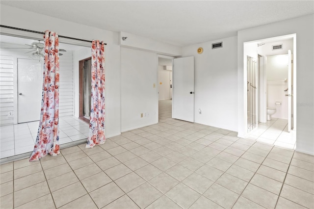 unfurnished room with ceiling fan and light tile patterned flooring