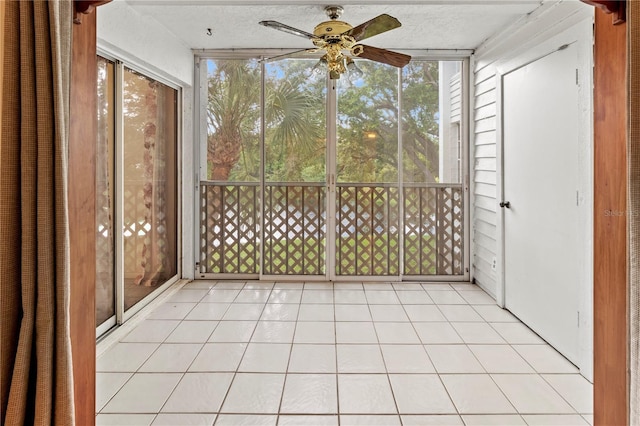 unfurnished sunroom with ceiling fan