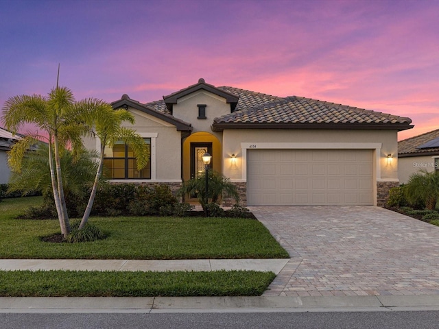 mediterranean / spanish house with a garage and a yard