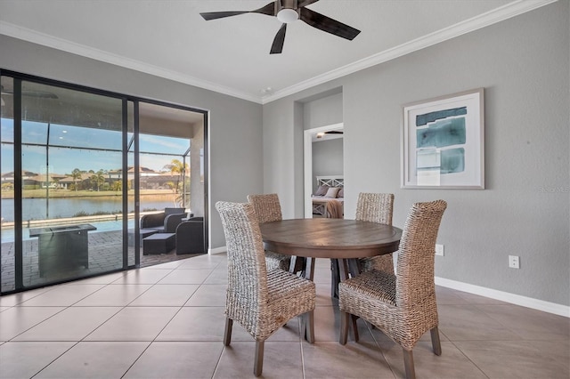 dining space with a water view, tile patterned floors, ornamental molding, and ceiling fan