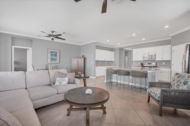 tiled living room featuring ornamental molding, sink, and ceiling fan