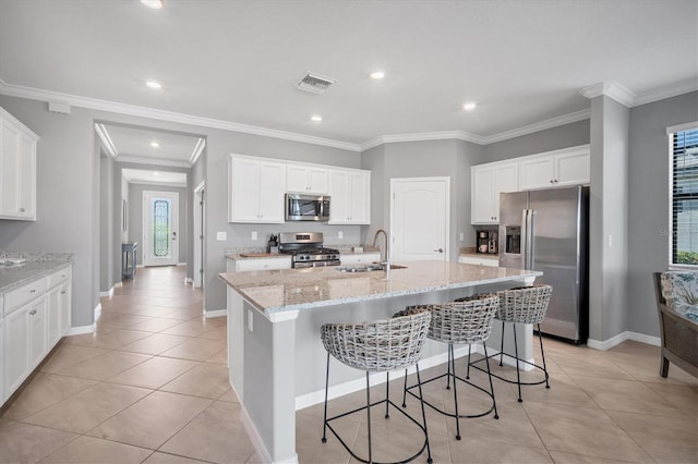 kitchen with a kitchen island with sink, sink, stainless steel appliances, and white cabinets