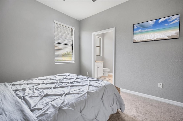 bedroom featuring connected bathroom and light carpet