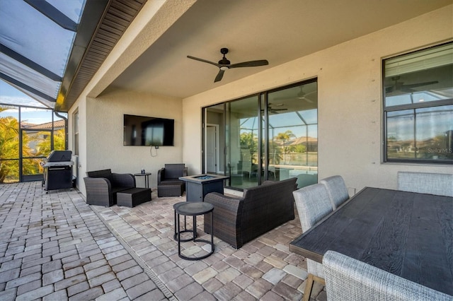 view of patio featuring ceiling fan, grilling area, an outdoor living space, and a lanai