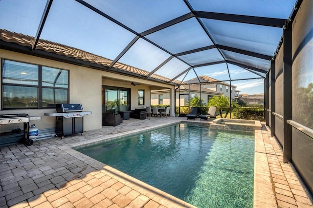 view of pool with grilling area, glass enclosure, an in ground hot tub, ceiling fan, and a patio