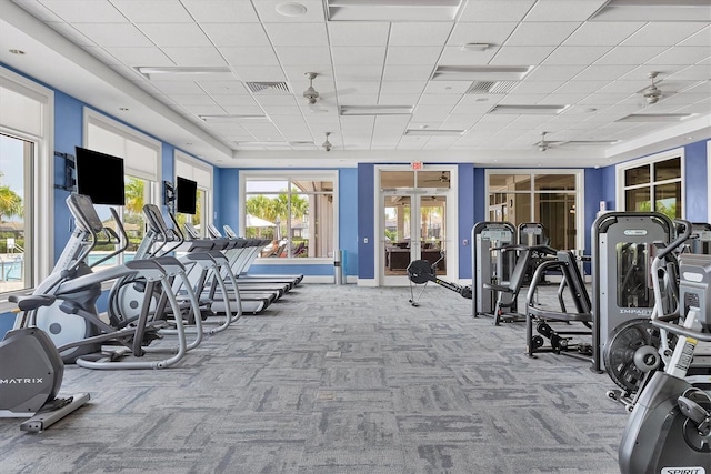 exercise room featuring ceiling fan and light colored carpet