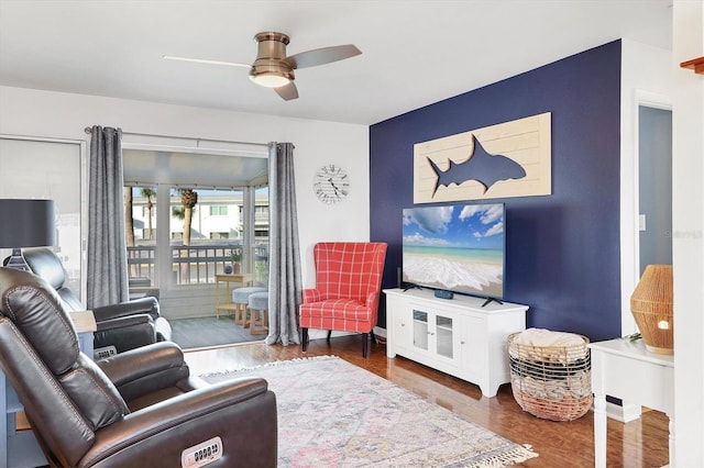 living room with dark wood-type flooring and ceiling fan