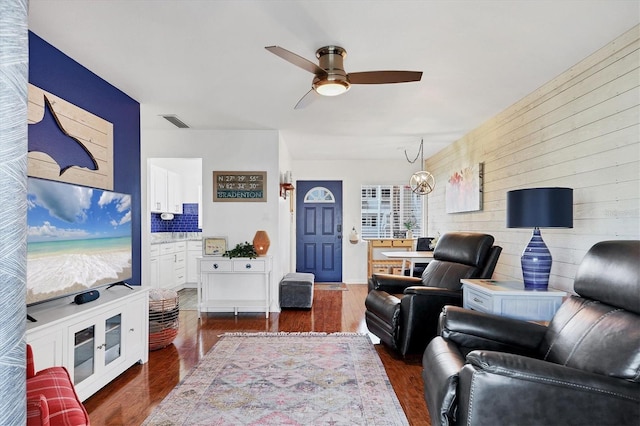 living room with dark wood-type flooring and ceiling fan