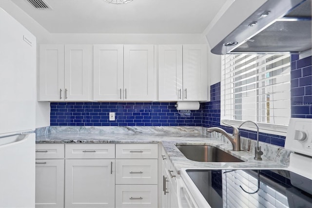 kitchen with sink, white cabinetry, tasteful backsplash, white refrigerator, and exhaust hood