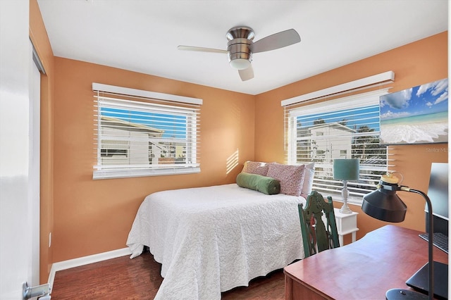 bedroom featuring multiple windows, dark wood-type flooring, a closet, and ceiling fan