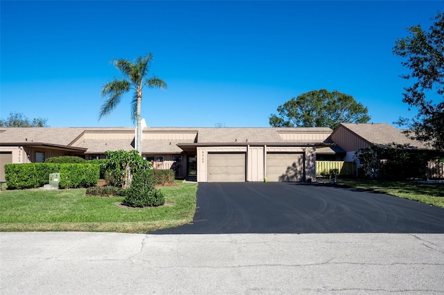 ranch-style home with a garage and a front lawn